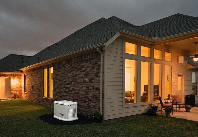 generac generator outside lit home at night