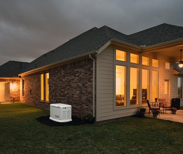 generac generator outside lit home at night